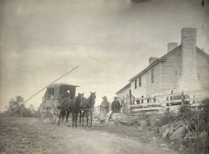 two horses drawing a covered wagon